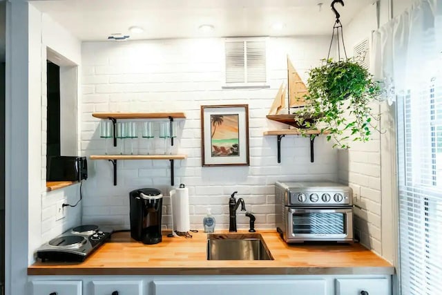 bar featuring decorative backsplash, a toaster, and a sink