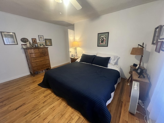 bedroom with baseboards, light wood finished floors, and ceiling fan