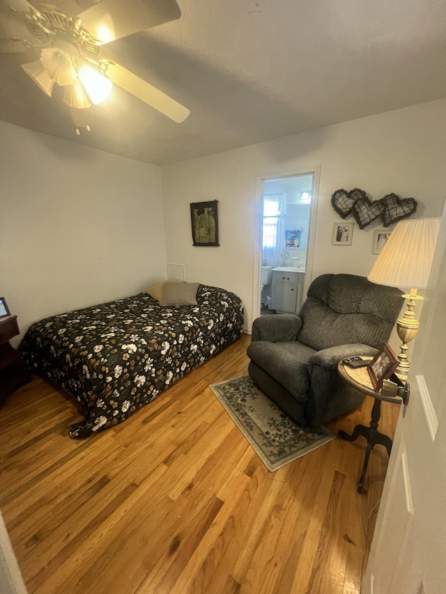 bedroom featuring ceiling fan, wood finished floors, and ensuite bathroom