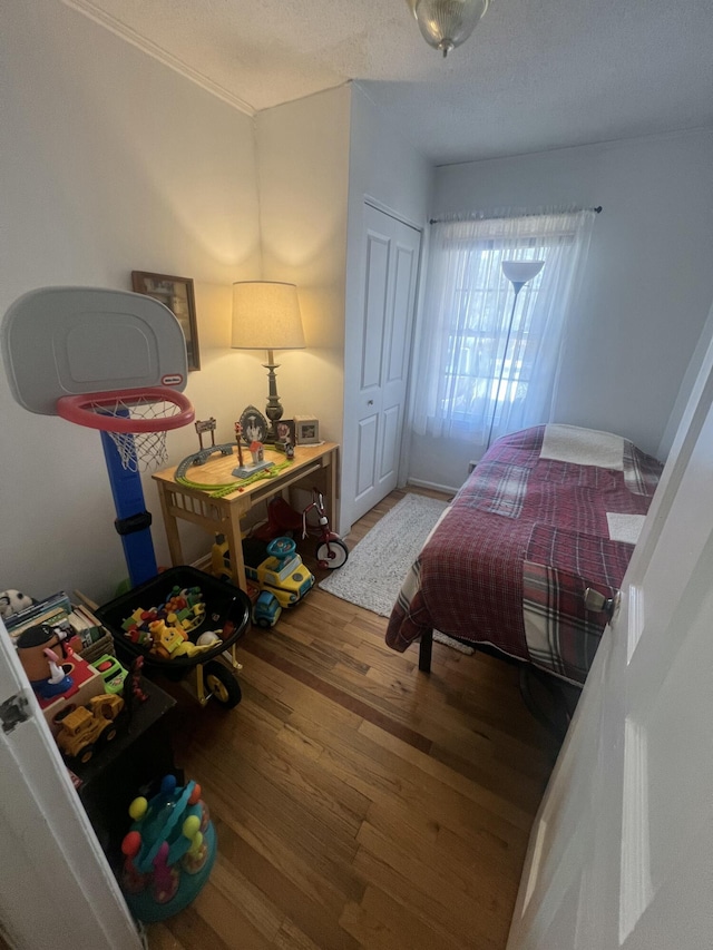 bedroom featuring a textured ceiling and wood finished floors