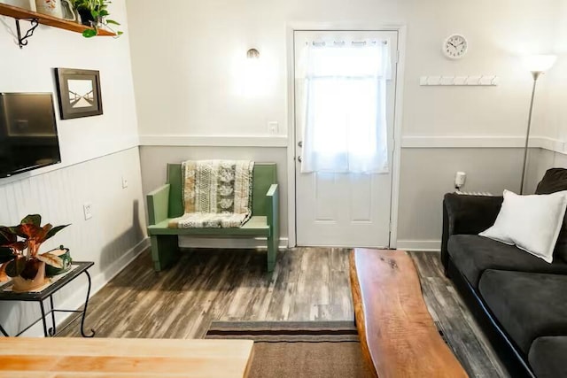 living area with baseboards and wood finished floors