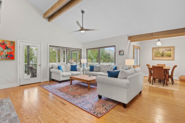 living room with ceiling fan, beam ceiling, light wood-type flooring, and high vaulted ceiling