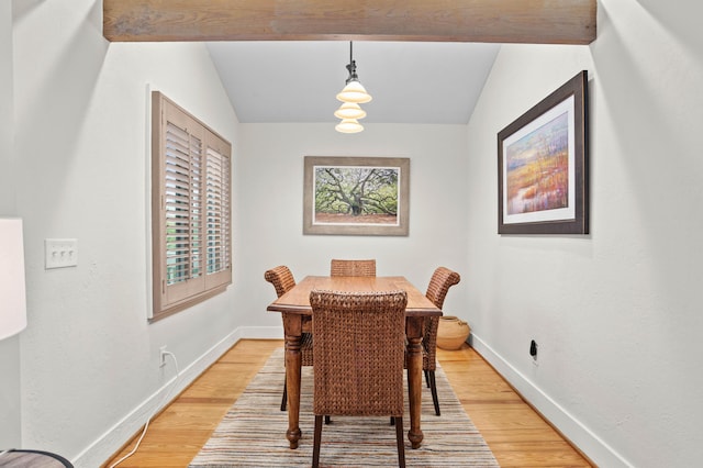 dining area featuring hardwood / wood-style floors and vaulted ceiling