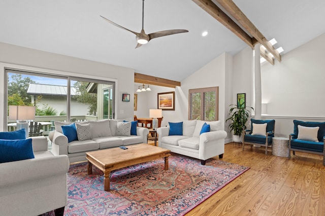 living room featuring beamed ceiling, high vaulted ceiling, ceiling fan with notable chandelier, and light wood-type flooring