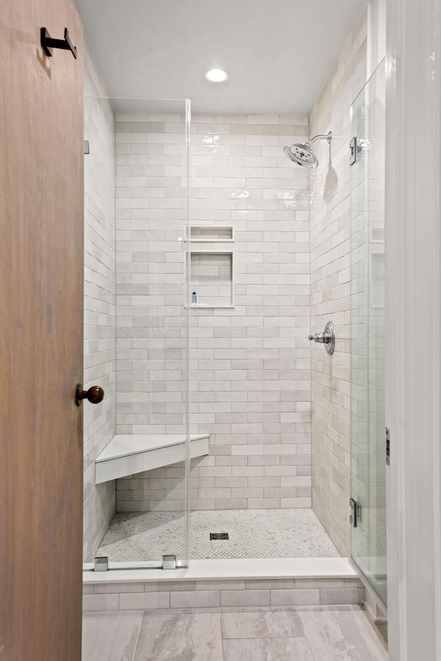 bathroom featuring a shower with shower door