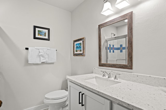 bathroom featuring vanity, toilet, and a shower with shower door