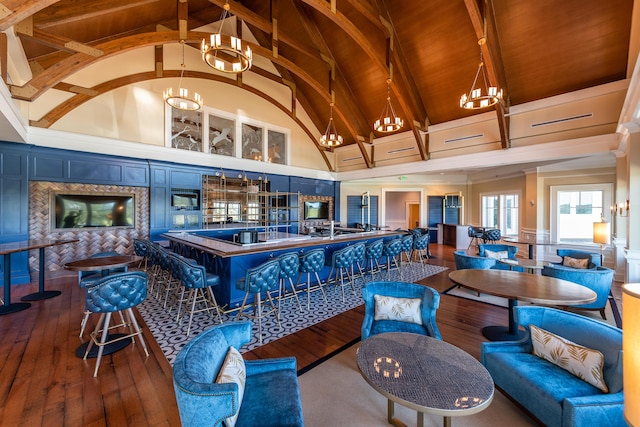 interior space with high vaulted ceiling, blue cabinets, hardwood / wood-style flooring, beamed ceiling, and decorative light fixtures