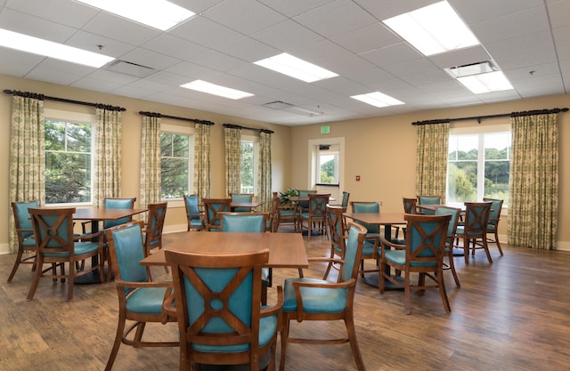 dining area featuring a paneled ceiling and dark wood-type flooring