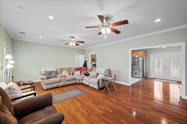 living room with baseboards, visible vents, crown molding, french doors, and light wood-style floors