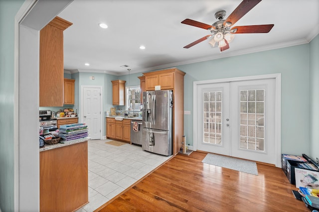 kitchen featuring light wood-style flooring, stainless steel appliances, light countertops, french doors, and crown molding