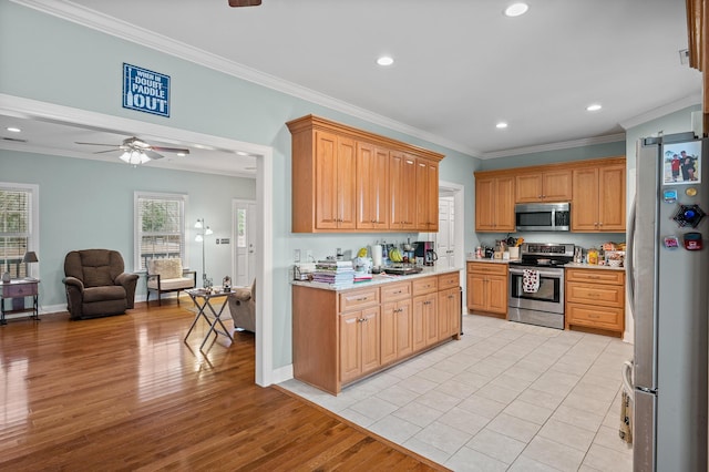 kitchen with appliances with stainless steel finishes, light wood-type flooring, open floor plan, and ornamental molding