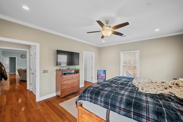 bedroom with ornamental molding, baseboards, and wood finished floors