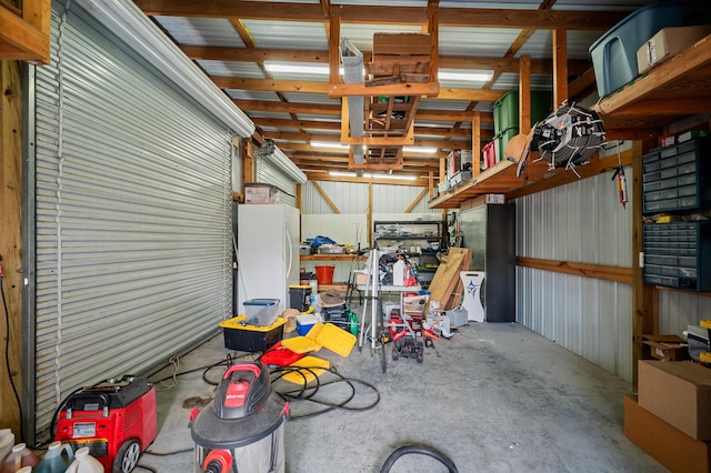 garage with freestanding refrigerator and metal wall