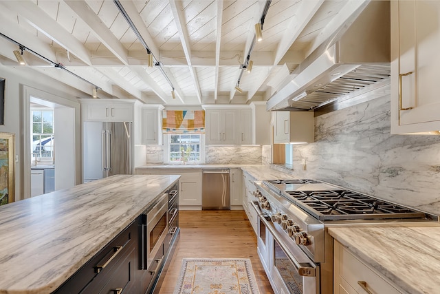 304 Bank St, Mount Pleasant, SC 29464 - kitchen featuring high quality appliances, wall chimney exhaust hood, light wood finished floors, white cabinetry, and light stone countertops