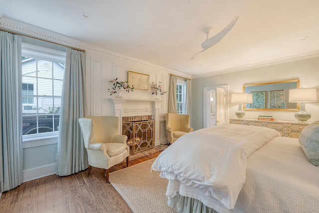304 Bank St, Mount Pleasant, SC 29464 - bedroom featuring crown molding, a lit fireplace, multiple windows, wood finished floors, and baseboards