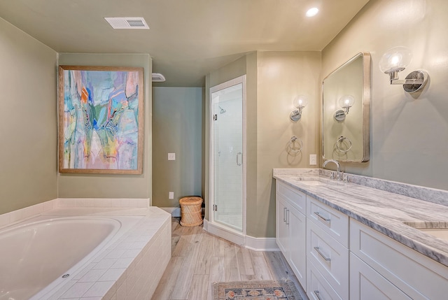 304 Bank St, Mount Pleasant, SC 29464 - full bath with double vanity, a stall shower, a garden tub, and wood finished floors