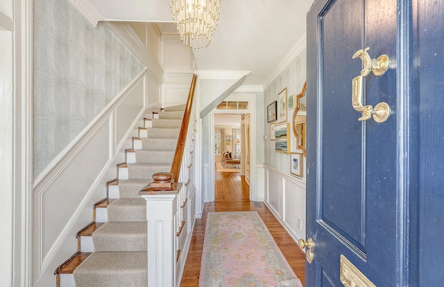 304 Bank St, Mount Pleasant, SC 29464 - entrance foyer featuring a decorative wall, stairway, wood finished floors, a chandelier, and crown molding