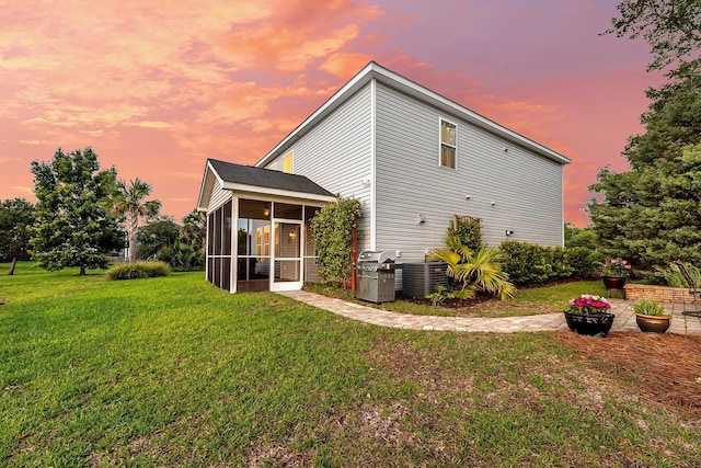 3310 Hartwell St, Johns Island, SC 29455 - back of house at dusk with a sunroom, a yard, and central air condition unit
