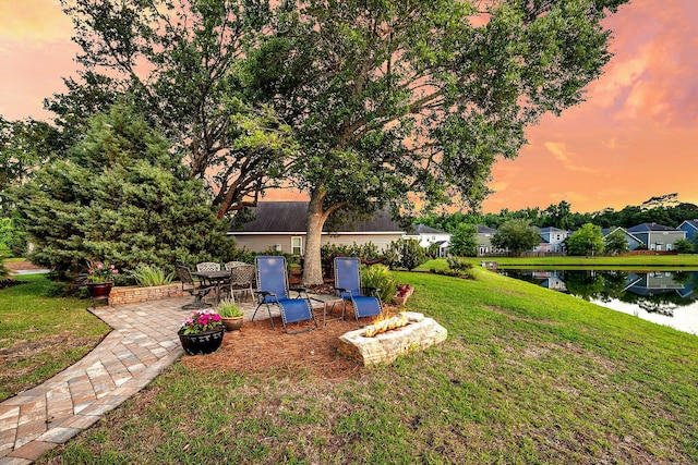 3310 Hartwell St, Johns Island, SC 29455 - yard at dusk featuring a water view, a fire pit, a patio, and a lawn