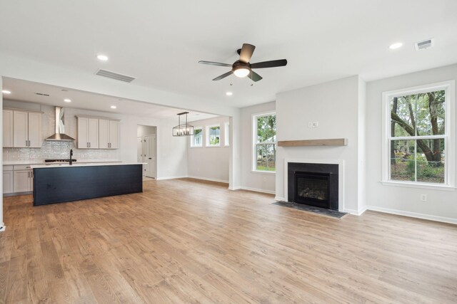 712 Minton Rd, James Island, SC 29412 - unfurnished living room featuring a fireplace with flush hearth, a ceiling fan, visible vents, and light wood-style flooring