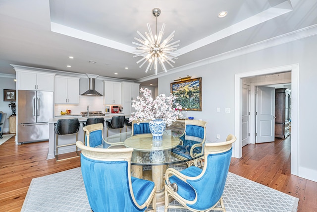 dining space featuring a tray ceiling, a chandelier, crown molding, and dark wood-type flooring