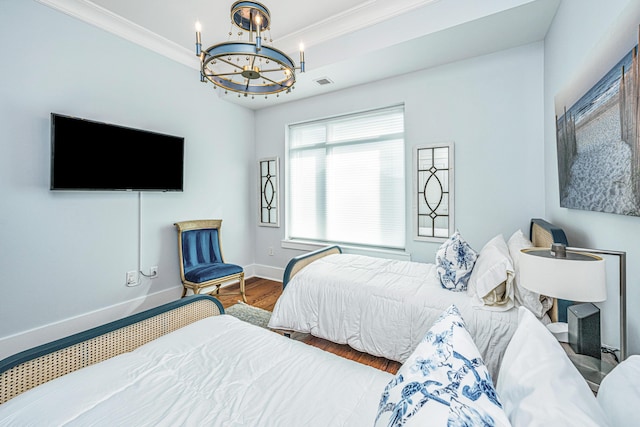 bedroom with ornamental molding, hardwood / wood-style flooring, and a notable chandelier