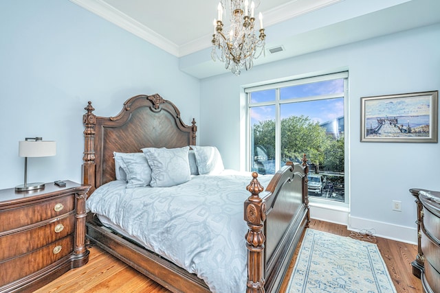 bedroom featuring a chandelier, hardwood / wood-style floors, and ornamental molding