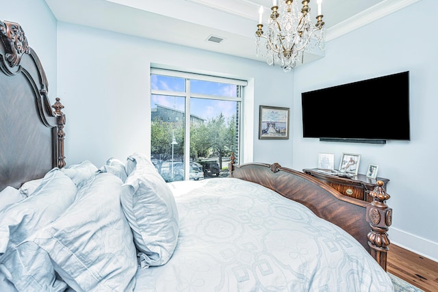 bedroom featuring access to outside, ornamental molding, a notable chandelier, and hardwood / wood-style flooring