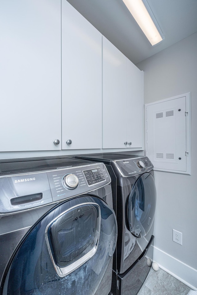 laundry area featuring washer and clothes dryer and cabinets