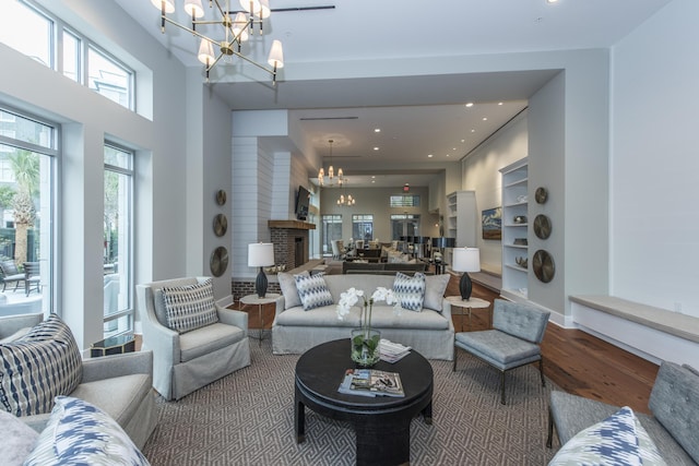 living room with hardwood / wood-style flooring, a fireplace, and a chandelier