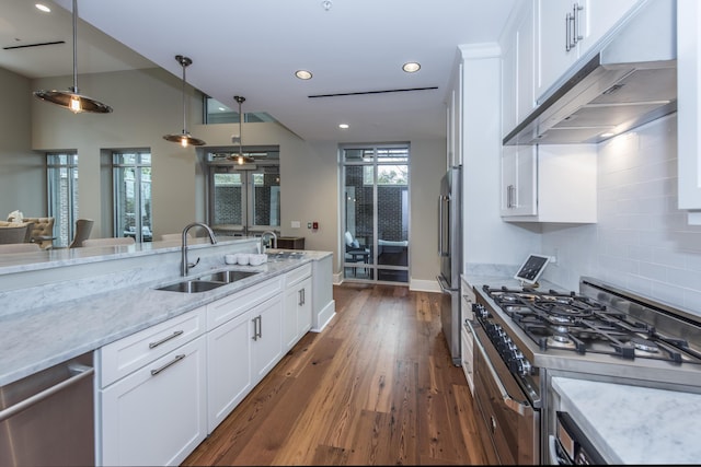 kitchen featuring high quality appliances, sink, white cabinets, and light stone counters