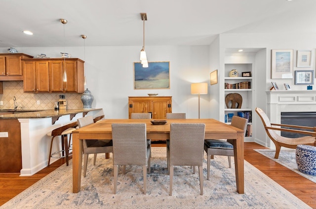 dining area featuring light hardwood / wood-style floors, sink, and built in features