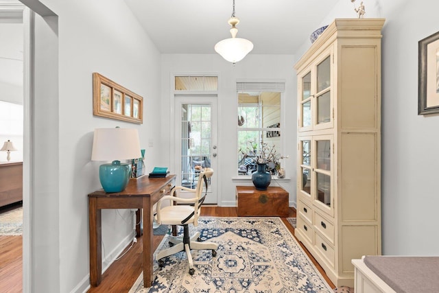 home office with light hardwood / wood-style flooring