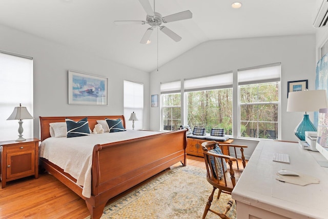 bedroom with vaulted ceiling, ceiling fan, light hardwood / wood-style floors, and a wall unit AC