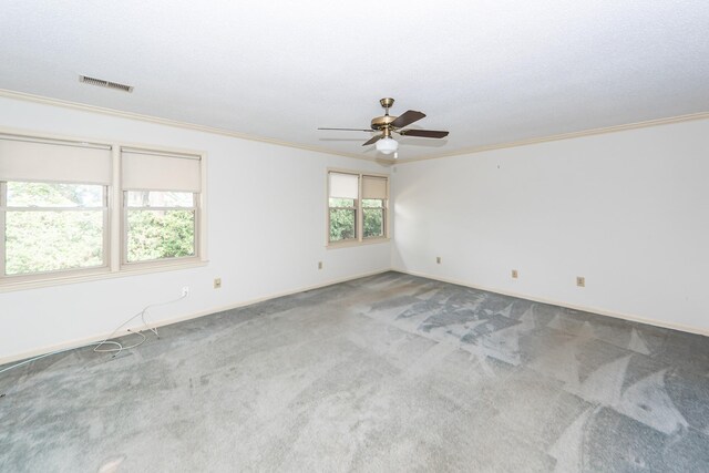 carpeted spare room featuring ceiling fan, a textured ceiling, and ornamental molding