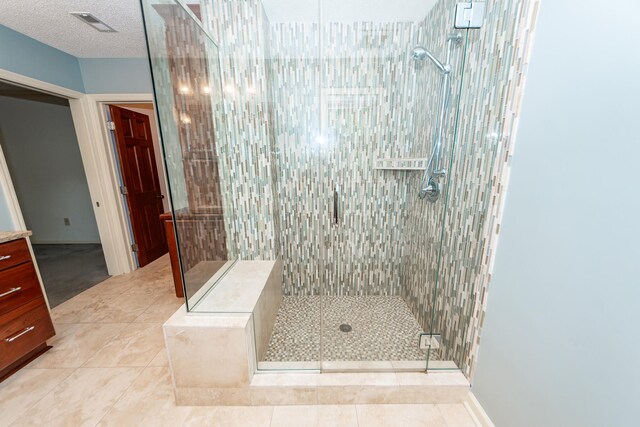 bathroom with a textured ceiling, tile patterned floors, and a shower with door