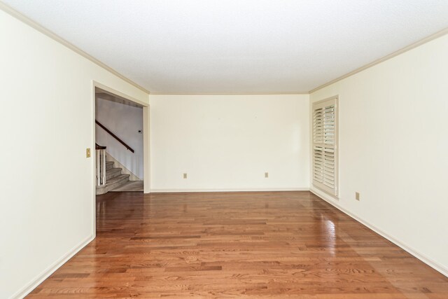 unfurnished room featuring hardwood / wood-style flooring and crown molding