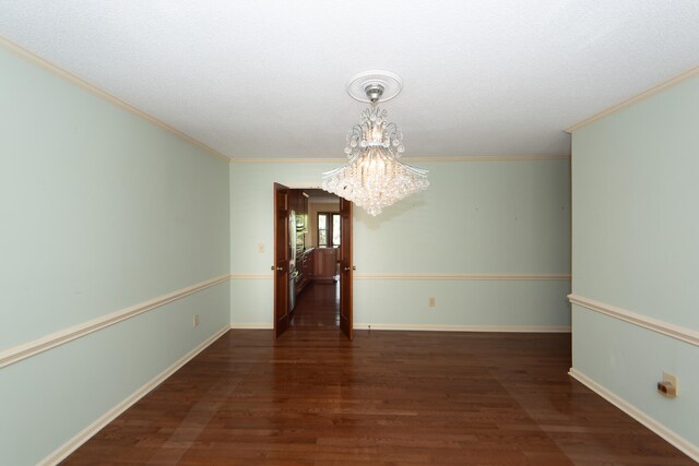 unfurnished dining area featuring ornamental molding, dark hardwood / wood-style floors, and an inviting chandelier