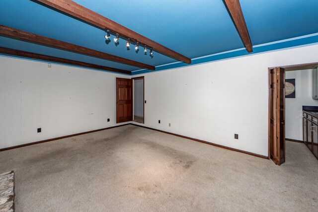 unfurnished room featuring light colored carpet and beam ceiling