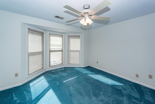 carpeted spare room with ceiling fan and a textured ceiling