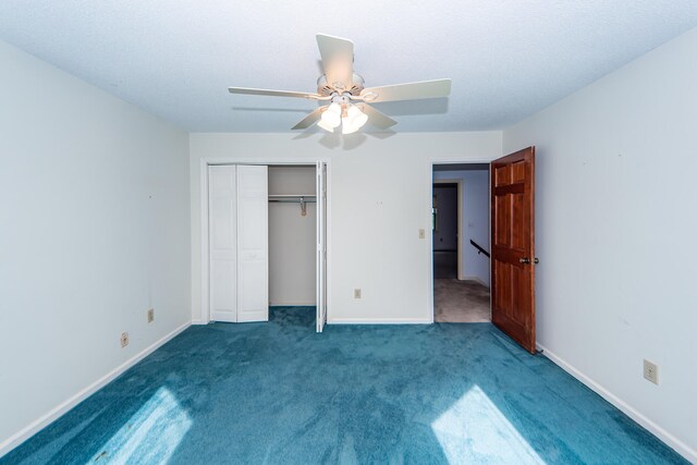 unfurnished bedroom with a closet, a textured ceiling, dark colored carpet, and ceiling fan