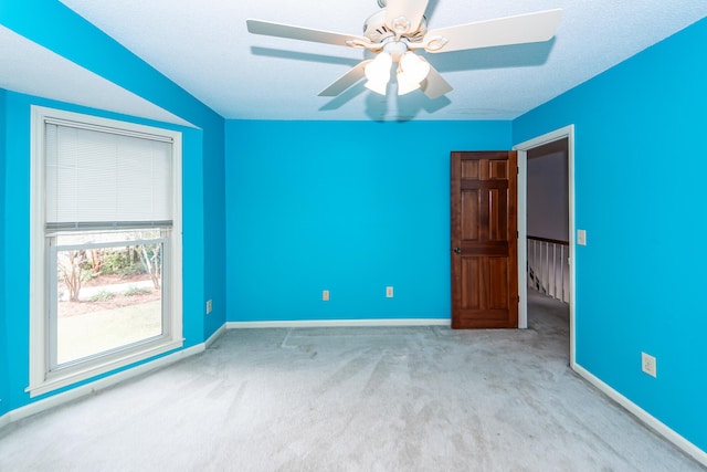 carpeted spare room featuring a textured ceiling and ceiling fan