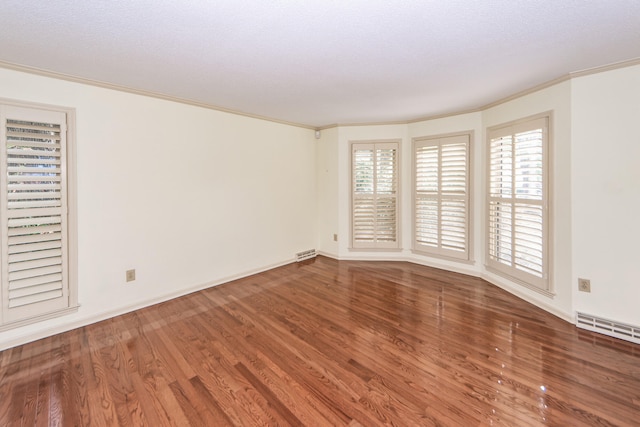 spare room with ornamental molding, hardwood / wood-style floors, and a textured ceiling