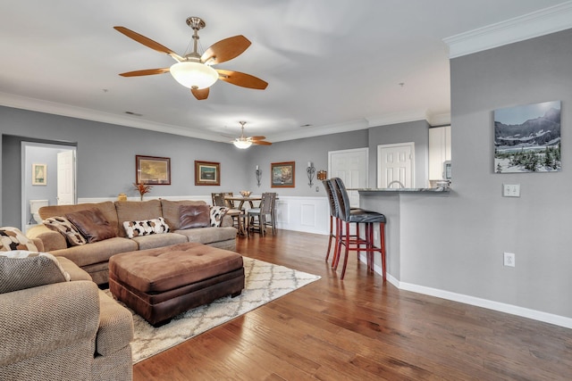 living room featuring ceiling fan, dark hardwood / wood-style flooring, and ornamental molding