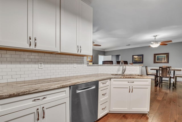 kitchen featuring a sink, stainless steel dishwasher, a peninsula, decorative backsplash, and ceiling fan