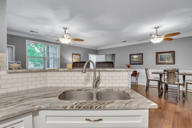 living room featuring ceiling fan, ornamental molding, and hardwood / wood-style flooring