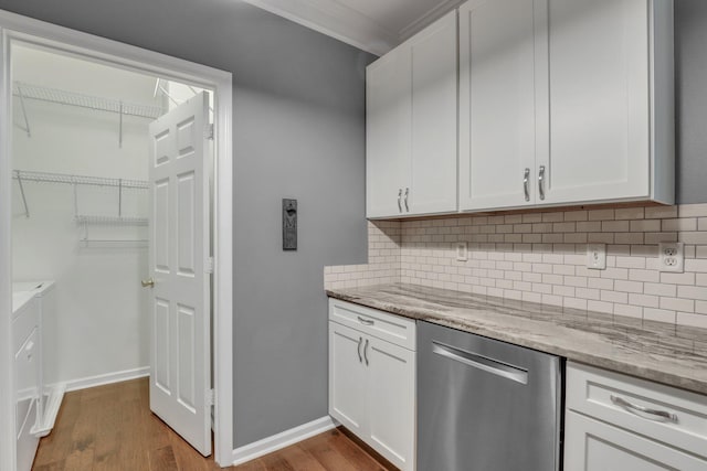 kitchen with tasteful backsplash, white cabinets, light stone countertops, dishwasher, and dark wood-style flooring