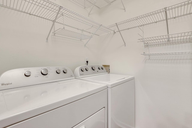 clothes washing area featuring laundry area and washer and clothes dryer