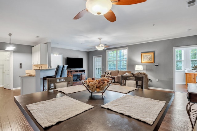 living area featuring visible vents, baseboards, and wood-type flooring