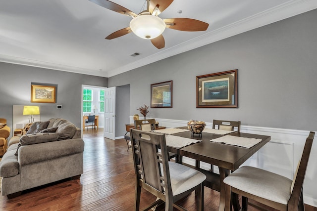 dining room with visible vents, a wainscoted wall, dark wood-type flooring, and ornamental molding